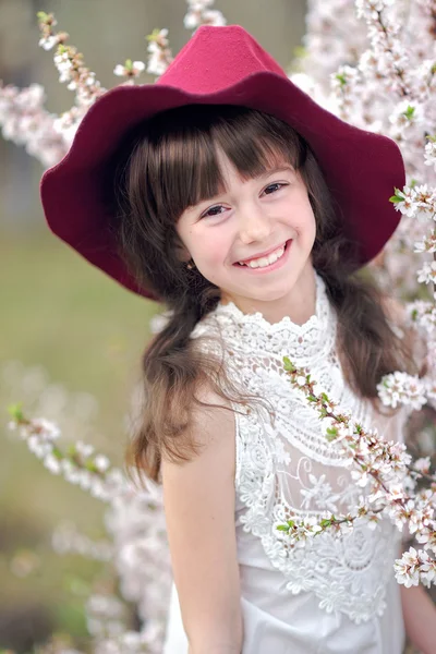 Portret van een mooi klein meisje met bloemen — Stockfoto