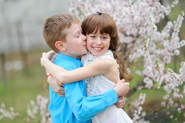 Retrato de um menino e menina no exuberante jardim — Fotografia de Stock