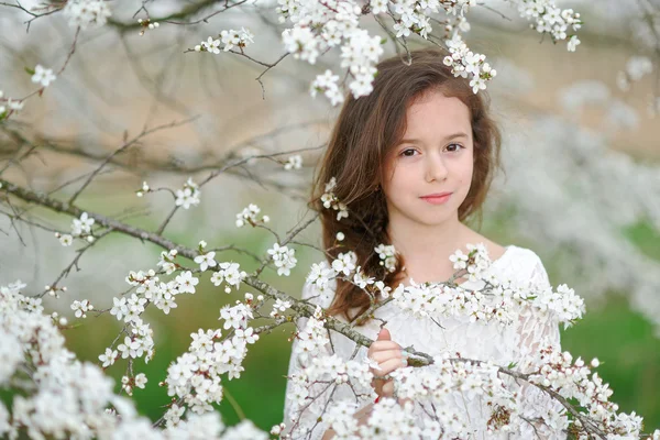 Portret van een mooi klein meisje met bloemen — Stockfoto