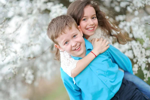 Retrato de un niño y una niña en el exuberante jardín — Foto de Stock