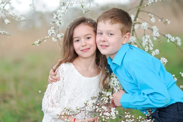 Portrait of a boy and girl in the lush garden — Stock Photo, Image