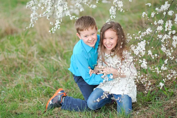 Portrait of a boy and girl in the lush garden — Stock Photo, Image