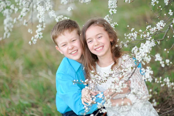 Retrato de um menino e menina no exuberante jardim — Fotografia de Stock