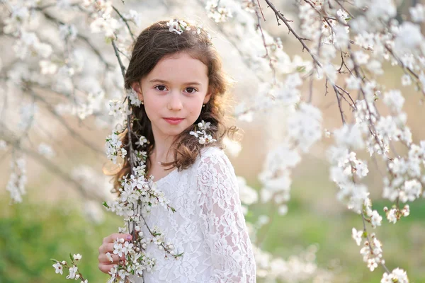 Portret van een mooi klein meisje met bloemen — Stockfoto