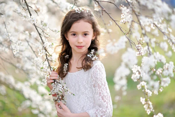 Porträtt av en vacker liten flicka med blommor — Stockfoto