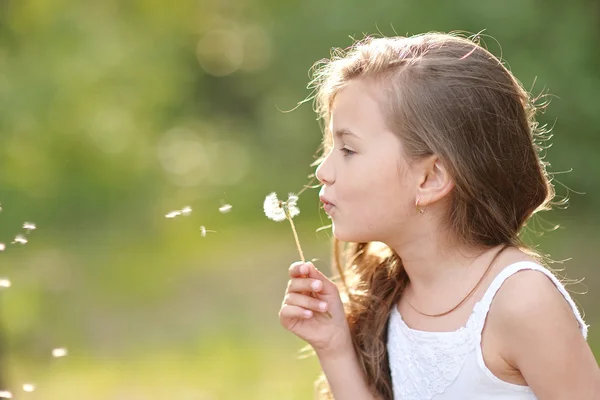 Porträtt av en vacker liten flicka med blommor — Stockfoto