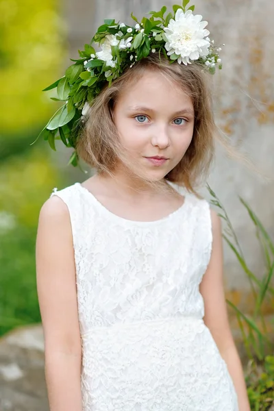 Porträtt av en vacker liten flicka med blommor — Stockfoto