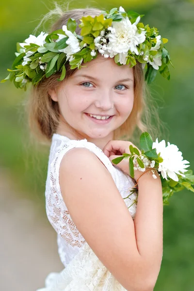 Porträtt av en vacker liten flicka med blommor — Stockfoto