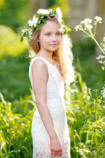 Porträtt av en vacker liten flicka med blommor — Stockfoto