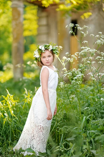 Portret van een mooi klein meisje met bloemen — Stockfoto