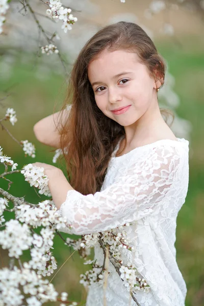 Portret van een mooi klein meisje met bloemen — Stockfoto