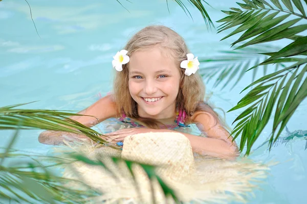 Портрет маленькой девочки в тропическом стиле в бассейне — стоковое фото