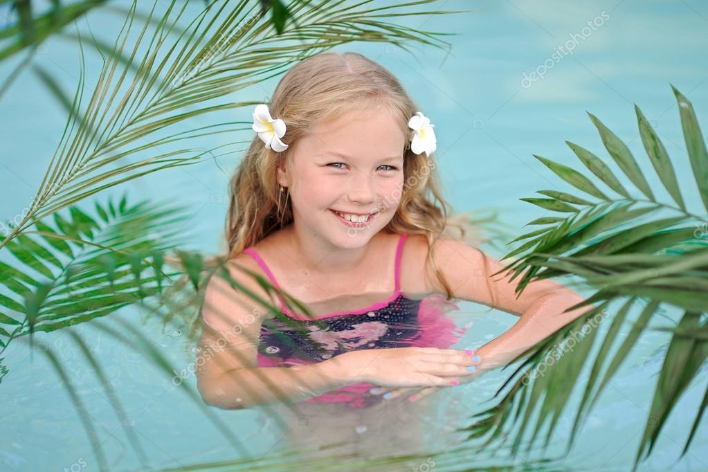 Portrait Of Little Girl In Tropical Style In A Swimming Pool Stock
