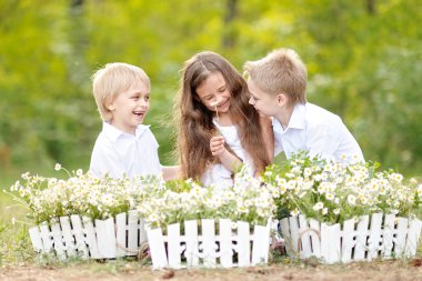 üç çocuklar yaz aylarında çayır üzerinde oyun