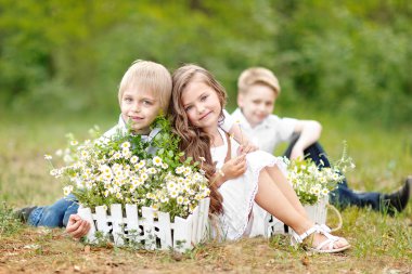 üç çocuklar yaz aylarında çayır üzerinde oyun