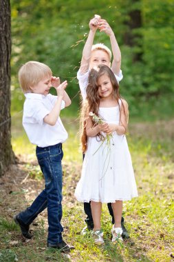 üç çocuklar yaz aylarında çayır üzerinde oyun