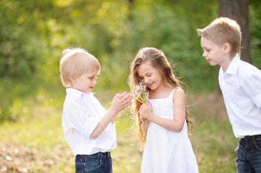 üç çocuklar yaz aylarında çayır üzerinde oyun
