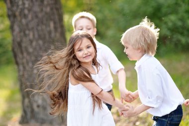 üç çocuklar yaz aylarında çayır üzerinde oyun