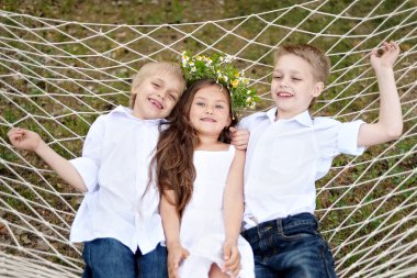 üç çocuklar yaz aylarında çayır üzerinde oyun