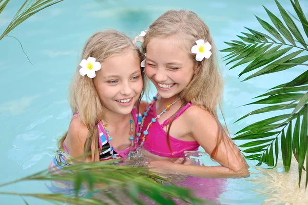 Portret van twee meisjes in een zwembad — Stockfoto