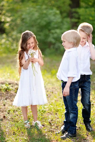 Drei Kinder spielen im Sommer auf Wiese — Stockfoto