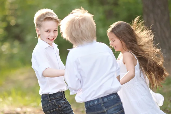 Tři děti si hrají na louce v létě — Stock fotografie