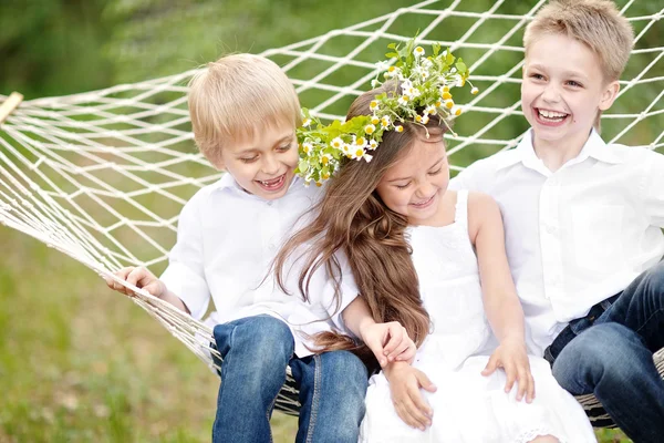 Trois enfants jouant sur la prairie en été — Photo