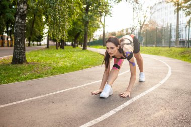 Parkta kinesioteyp eğitimi almış esnek bir kadın..