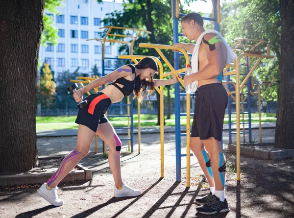 Spor sahasında kineziyolojik elastik bantları olan bir çift..