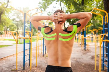 Spor sahasında poz veren elastik bantlı tanınmayan bir adam..