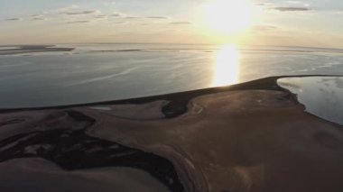 Parlak bir göl ve renkli bir günbatımında alışılmadık adalar