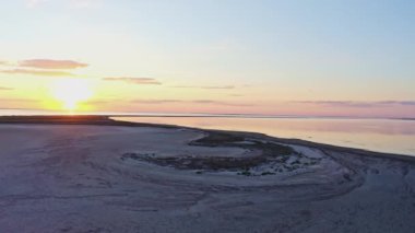 Parlak bir göl ve renkli bir günbatımında alışılmadık adalar