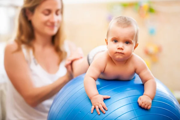 Baby spelen met fitness bal met moeder thuis. — Stockfoto