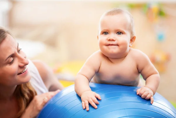 Babyträning med gymnastikboll med mamma hemma. — Stockfoto