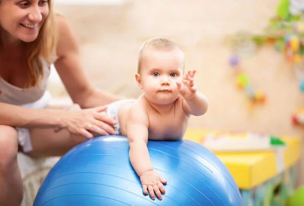 赤ちゃん遊びとともに体操ボールとともにお母さん-ホーム. — ストック写真