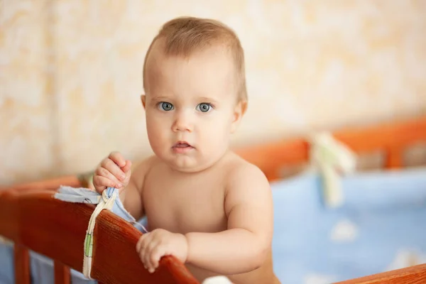 赤身裸体的快乐婴儿站在婴儿床里. — 图库照片