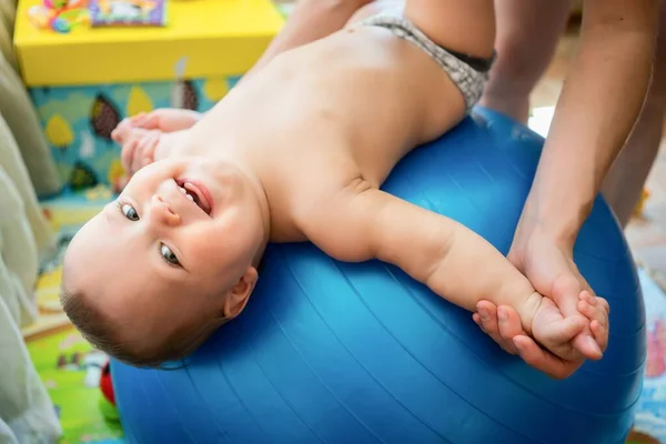 Entrenamiento de niños pequeños con pelota gimnástica con madre en casa. — Foto de Stock