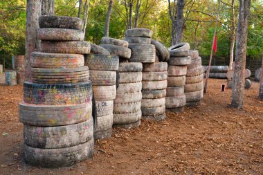 Paintball sahasında bir sürü eski ve hasarlı lastik var.