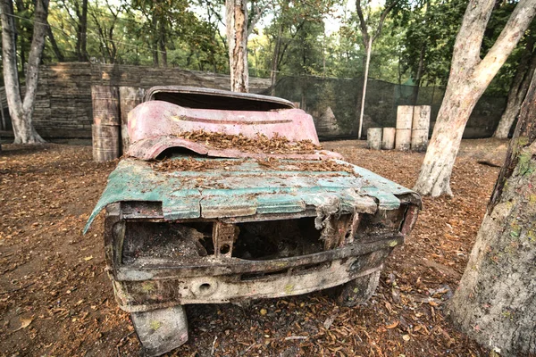 Viejo coche oxidado y abandonado en la base de paintball — Foto de Stock