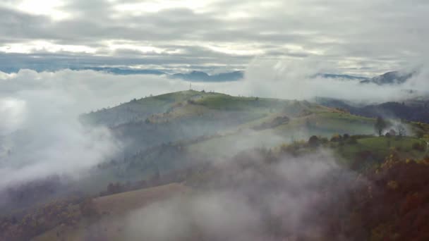 Vlieg over landschappen van groene heuvels onder een laag witte en pluizige wolken — Stockvideo