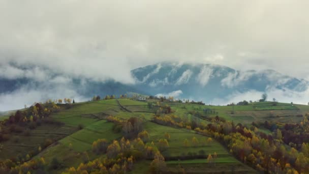 Gripe sobre paisagens de colinas verdes sob uma camada de nuvens brancas e fofas — Vídeo de Stock