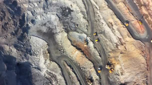 Huge Belaz trucks driving on the pit bottom in mining factory, mine quarry in Ukraine — Stock Video