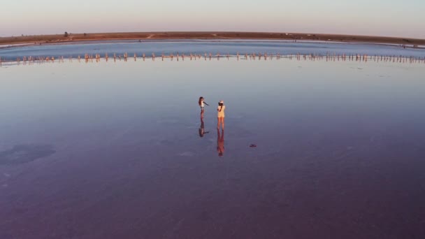Twee meisjes brengen tijd door op een zoutmeer. — Stockvideo