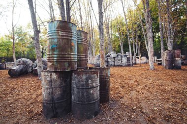 Paintball oynamak için kalede bir sürü eski yuvarlak fıçı var. Oyuncular bu oyunun arkasında saklanıyor.