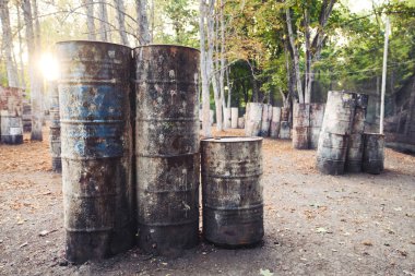 Paintball oynamak için kalede bir sürü eski yuvarlak fıçı var. Oyuncular bu oyunun arkasında saklanıyor.