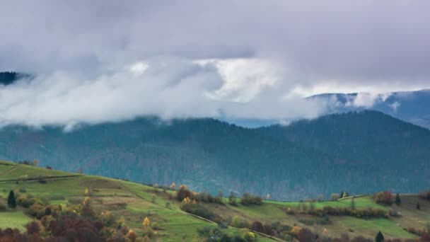 Landschappen van groene heuvels onder een laag witte en pluizige wolken — Stockvideo