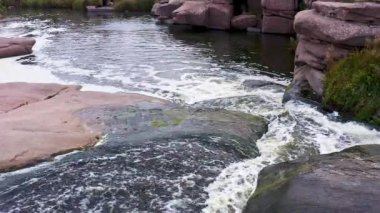 Yumuşak, karanlık ve ıslak taşların arasında hızlı bir dere.