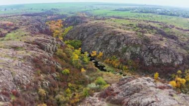 Ukrayna 'daki Aktovsky Kanyonu sonbahar ağaçları ve büyük taş kayalarla çevrili.