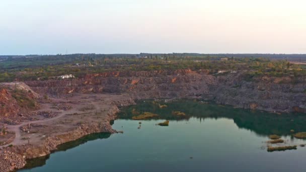 Old flooded stone quarry surrounded by large stones — Stock Video