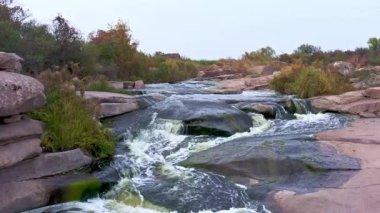 Yumuşak, karanlık ve ıslak taşların arasında hızlı bir dere.
